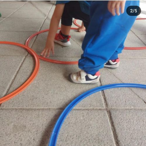 Imagen de piernas de niños jugando con aros en patio exterior