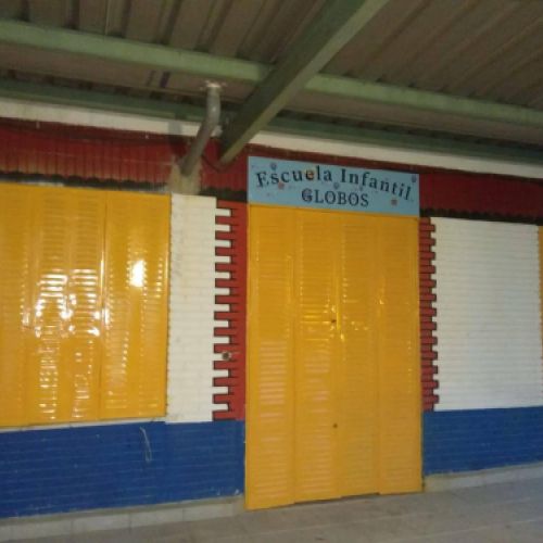 Entrada de la escuela con puertas y pared de color amarillo y azul