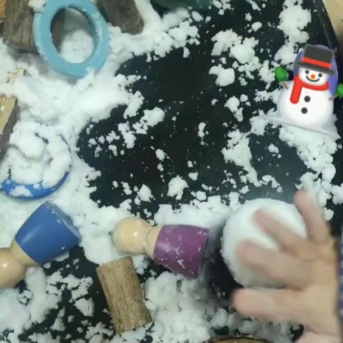 Primer plano de mano de niño manipulando una bola de nieve en zona de manualidades